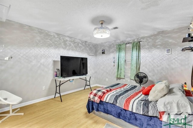 bedroom featuring hardwood / wood-style flooring and a textured ceiling