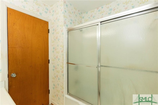 bathroom featuring combined bath / shower with glass door