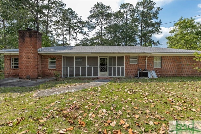 rear view of house featuring a patio, a sunroom, cooling unit, and a lawn