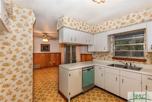 kitchen with dishwashing machine, sink, ceiling fan, white cabinets, and kitchen peninsula