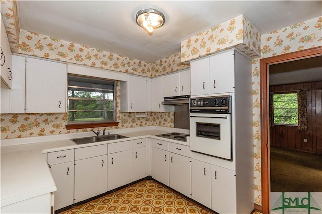 kitchen featuring white cabinetry, sink, and white appliances