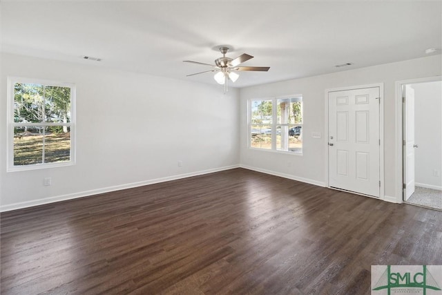 spare room featuring dark wood-type flooring and ceiling fan