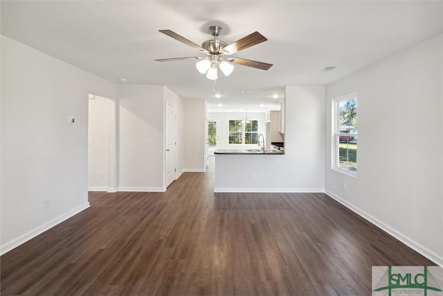 unfurnished living room featuring dark hardwood / wood-style flooring, sink, and ceiling fan