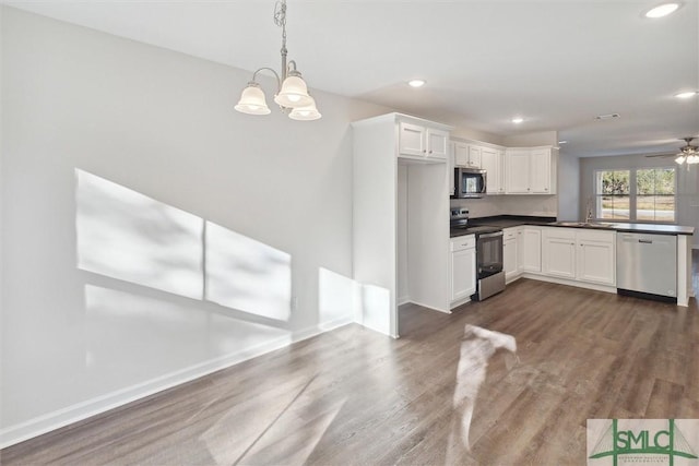 kitchen featuring pendant lighting, white cabinetry, stainless steel appliances, and dark hardwood / wood-style floors