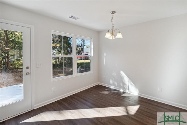 unfurnished dining area with dark hardwood / wood-style floors and a notable chandelier