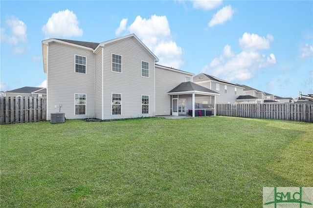 rear view of house featuring cooling unit, a yard, and a patio