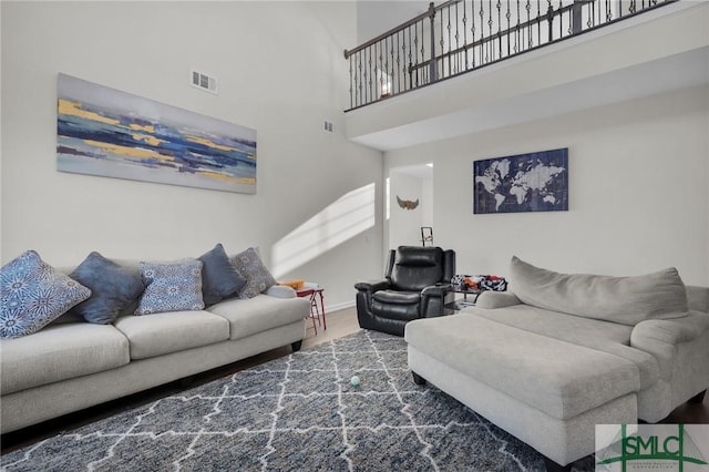 living room featuring a towering ceiling and hardwood / wood-style floors