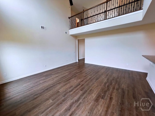 125 Grimsby Rd, Savannah, GA 31407 - unfurnished living room with a towering ceiling, baseboards, and wood finished floors