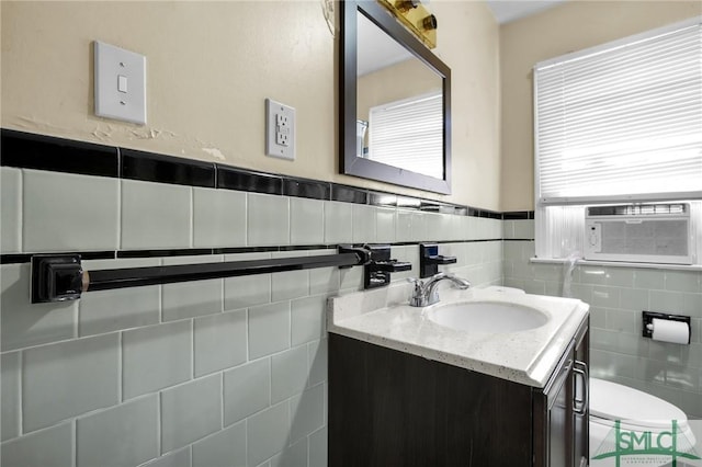 bathroom featuring vanity, toilet, and tile walls