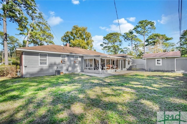 back of property featuring a yard, a patio area, and an outdoor structure