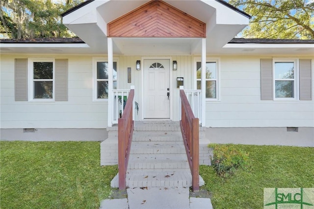 view of exterior entry featuring a lawn