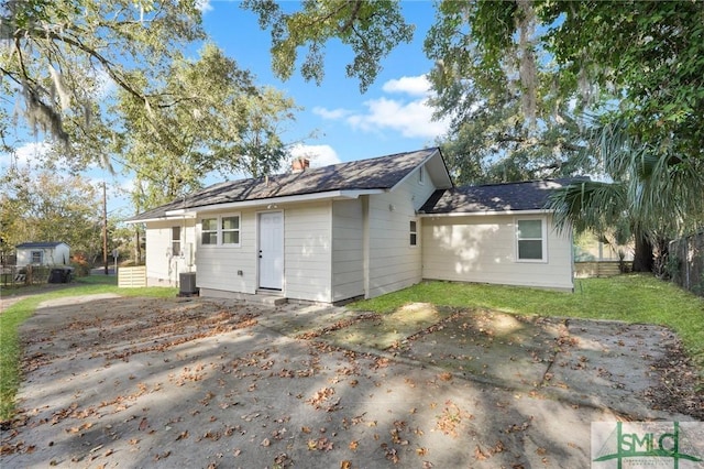 back of property with a yard, central air condition unit, and a patio area