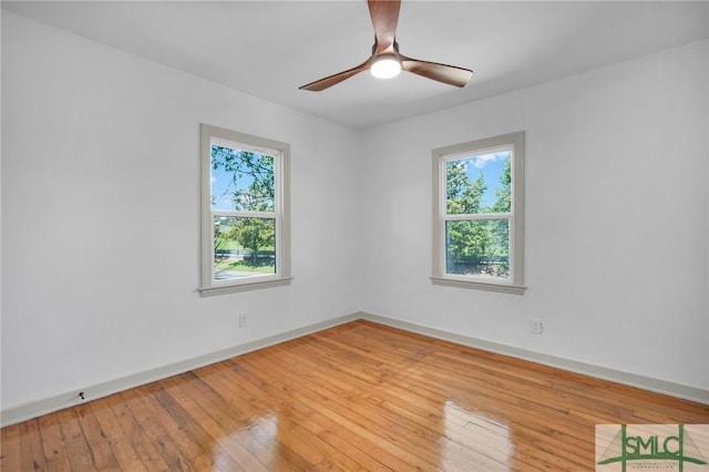 empty room with a wealth of natural light, ceiling fan, and light hardwood / wood-style flooring