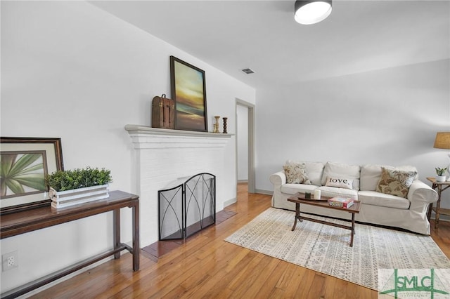 living room with hardwood / wood-style floors and a fireplace