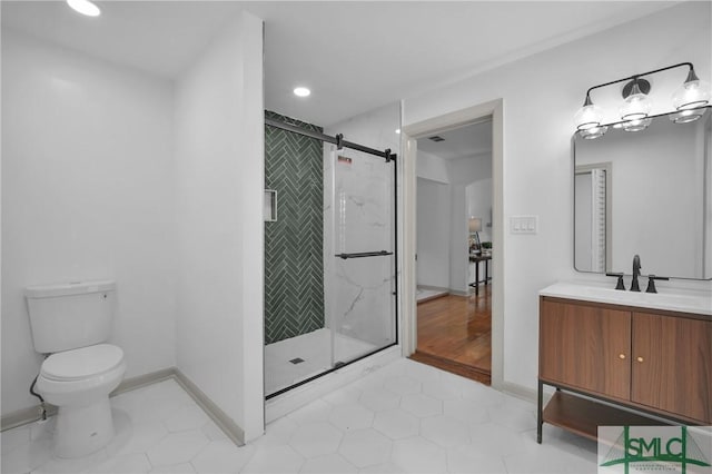 bathroom featuring vanity, toilet, and a shower with shower door