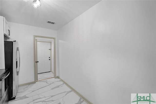 interior space featuring stainless steel appliances and white cabinets