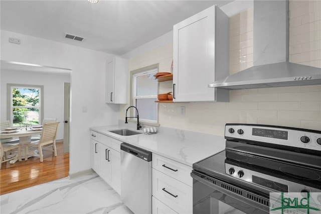 kitchen featuring sink, white cabinetry, range with electric stovetop, stainless steel dishwasher, and wall chimney range hood