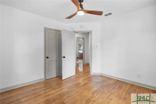 empty room with ceiling fan and light hardwood / wood-style flooring