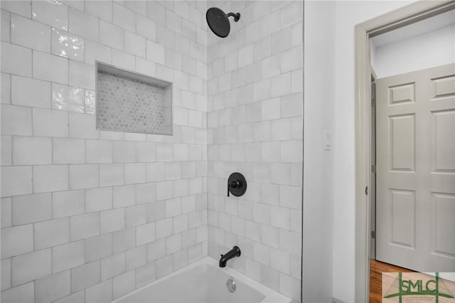 bathroom with tiled shower / bath combo and wood-type flooring