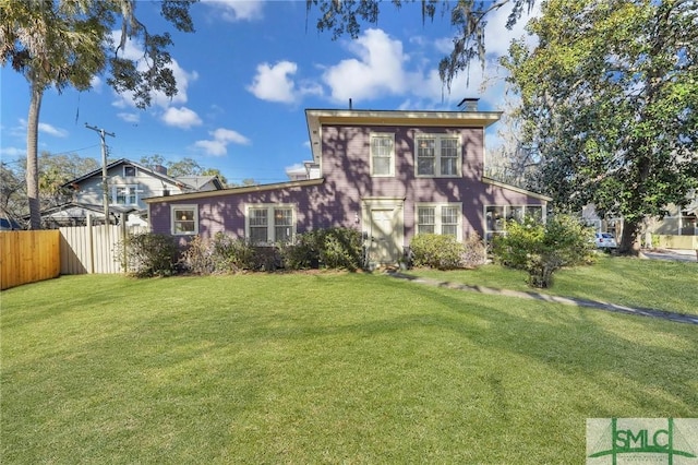 rear view of house featuring a yard