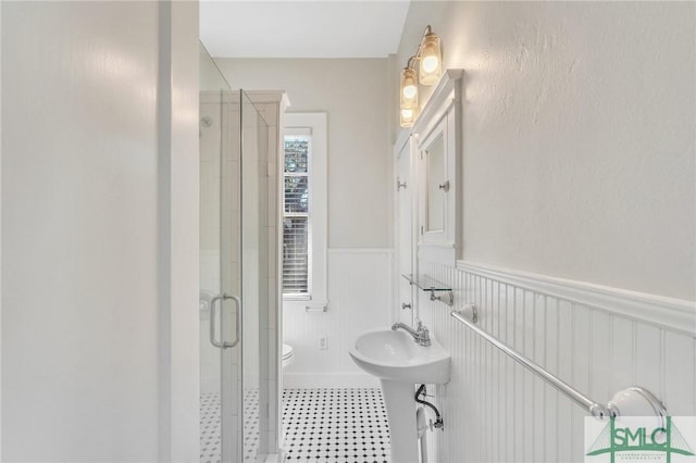 bathroom featuring toilet and an enclosed shower