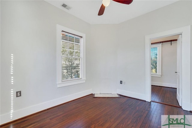 spare room featuring dark wood-type flooring, plenty of natural light, and ceiling fan