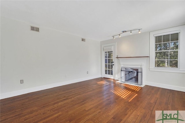 unfurnished living room with hardwood / wood-style flooring and track lighting