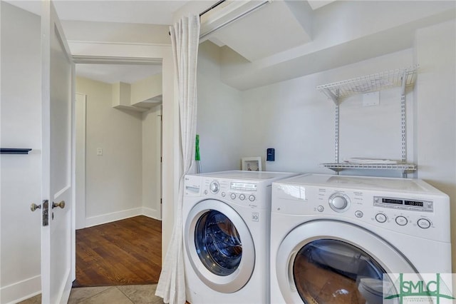 laundry area with washer and clothes dryer and light wood-type flooring