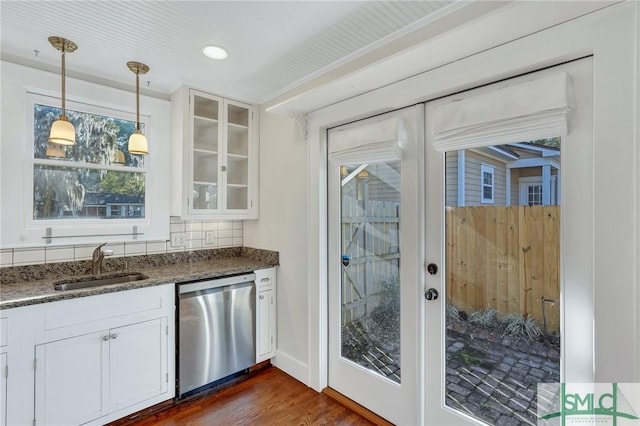 bar with pendant lighting, white cabinets, sink, and dishwasher