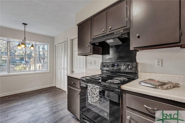 kitchen with pendant lighting, black electric range oven, dark wood-type flooring, dark brown cabinetry, and a notable chandelier