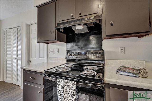 kitchen featuring hardwood / wood-style flooring, dark brown cabinetry, and black range with electric stovetop