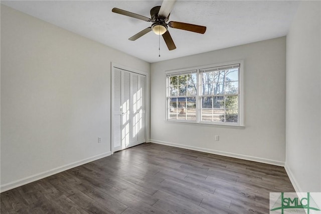 unfurnished room featuring dark wood-type flooring and ceiling fan