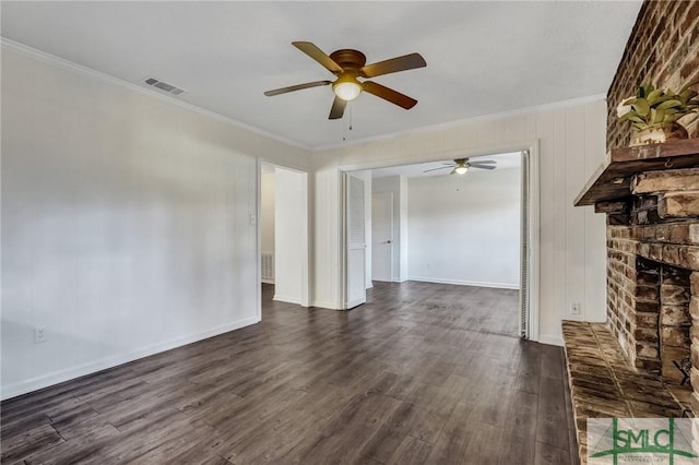 unfurnished living room with ornamental molding, a brick fireplace, dark hardwood / wood-style floors, and ceiling fan