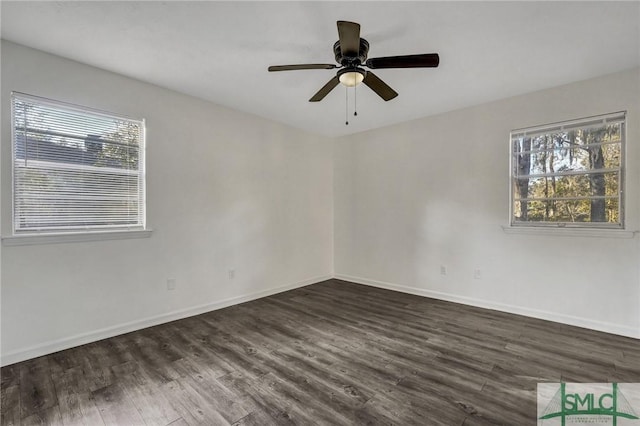 empty room with dark wood-type flooring, ceiling fan, and a healthy amount of sunlight