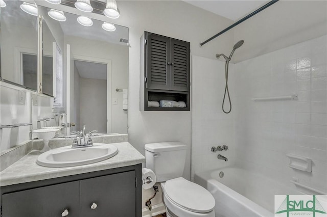 full bathroom featuring tiled shower / bath, vanity, and toilet