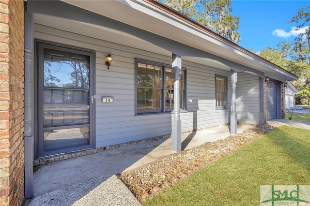 entrance to property featuring a yard and covered porch