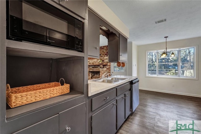 kitchen featuring sink, a textured ceiling, dark hardwood / wood-style flooring, decorative light fixtures, and stainless steel dishwasher