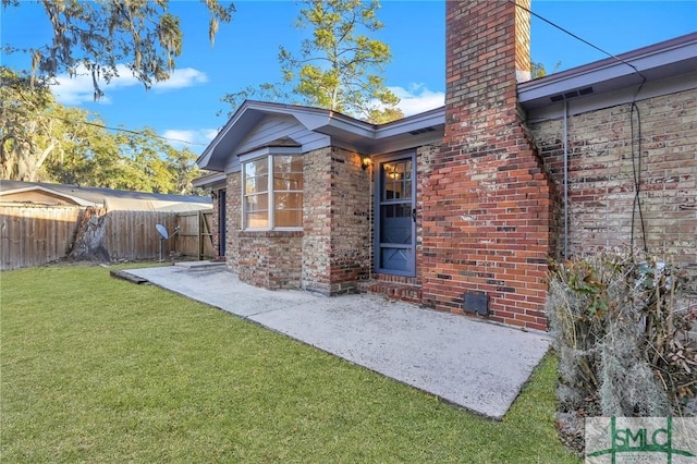 rear view of house featuring a yard and a patio area