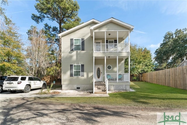 view of front of house featuring a balcony, covered porch, and a front yard