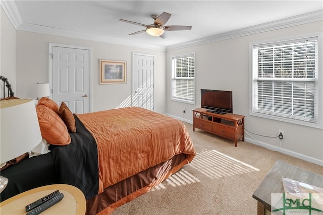 carpeted bedroom featuring ornamental molding, ceiling fan, and a closet