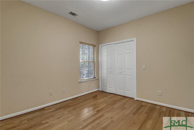 unfurnished bedroom featuring a closet and light hardwood / wood-style flooring