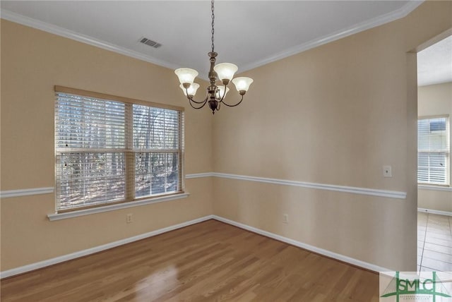 spare room featuring wood-type flooring, a healthy amount of sunlight, and ornamental molding