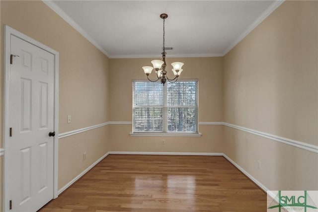 unfurnished dining area featuring crown molding, a notable chandelier, and hardwood / wood-style flooring