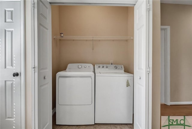 washroom featuring light tile patterned flooring and washing machine and clothes dryer