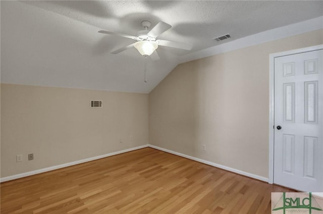 bonus room with vaulted ceiling, ceiling fan, light hardwood / wood-style floors, and a textured ceiling