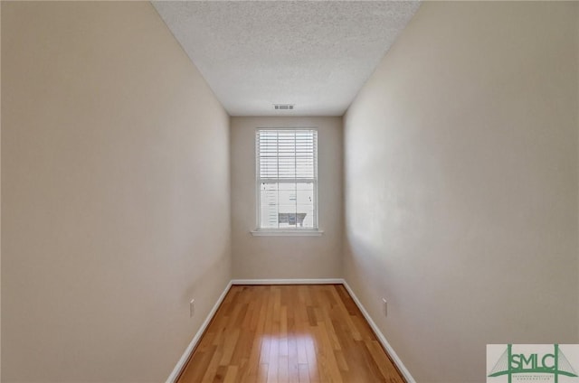 empty room with hardwood / wood-style floors and a textured ceiling