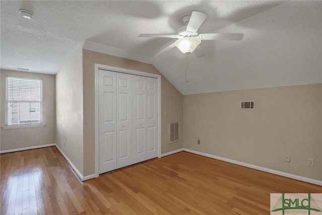 bonus room with vaulted ceiling, ceiling fan, and light wood-type flooring