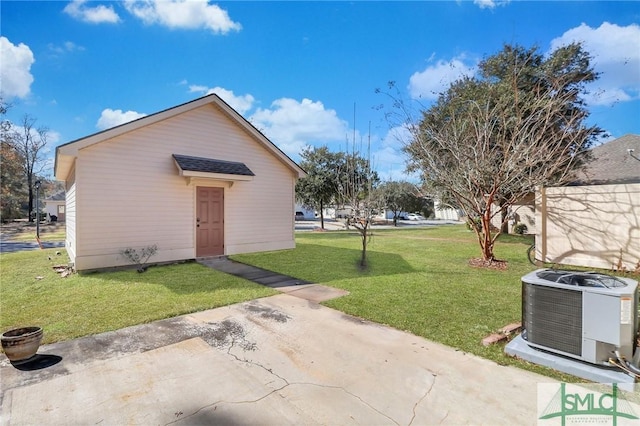 view of outbuilding with a yard and central AC unit