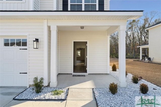 entrance to property featuring a garage and covered porch