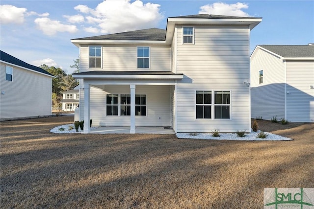 back of property with a patio and a lawn